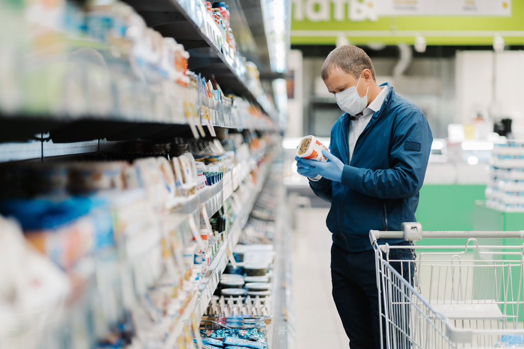 masked male looking at food label