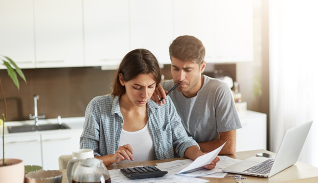 A couple calculating costs in their kitchen