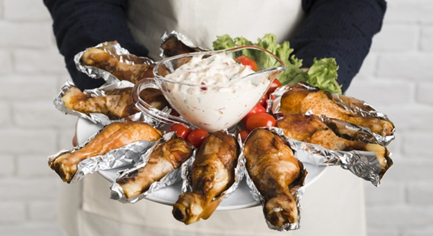 A chef holding a chicken platter