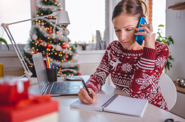 A woman working from a Christmas-embellished home office