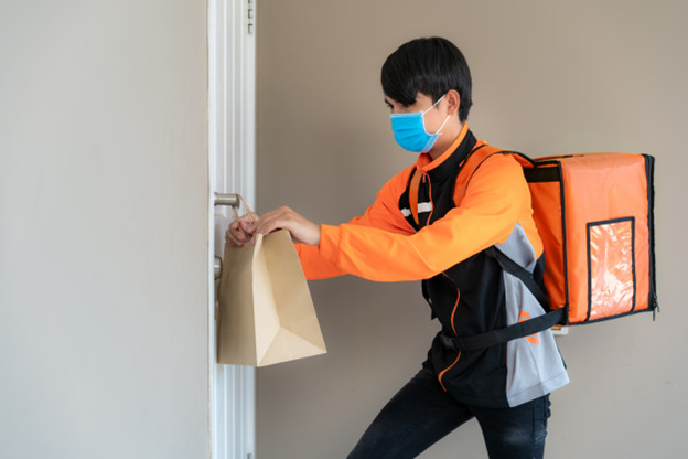 A delivery person leaving a bag at the doorknob