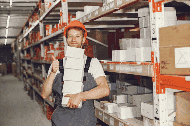 An employee working inside a big warehouse