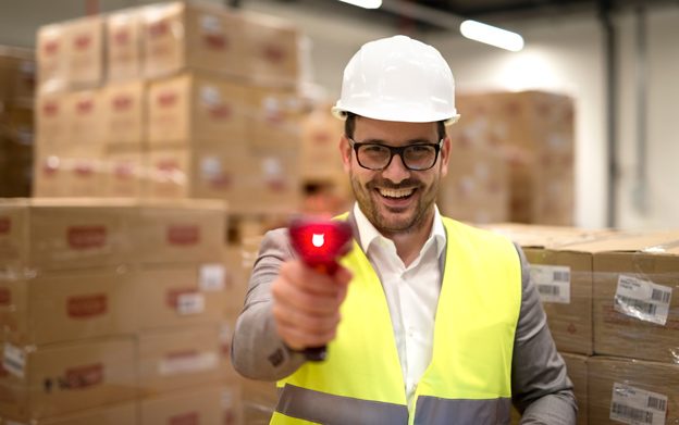 portrait-factory-warehouse-worker-standing-among-cardboard-boxes-holding-bar-code-scanner-laser-beam-pointing-camera